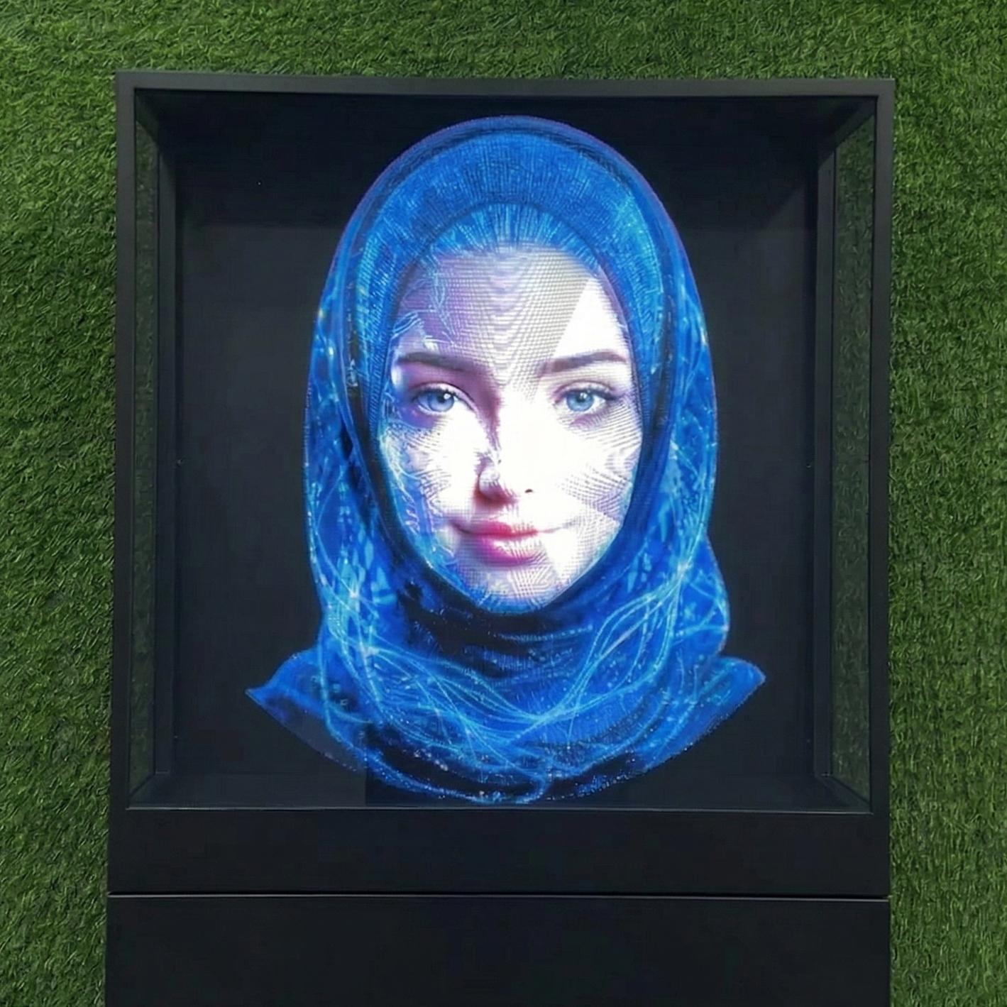 AI kiosk at an event features a digital display of a ai hologram woman in a blue hijab